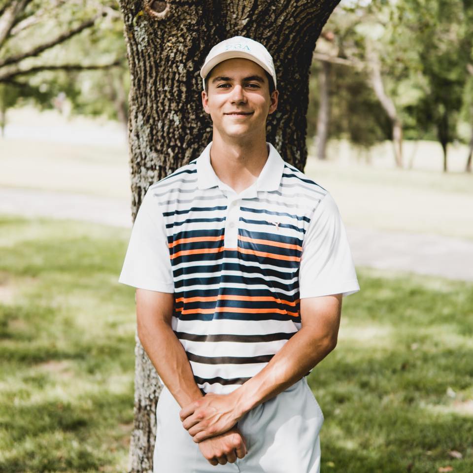Drew Taylor posing in front of a tree
